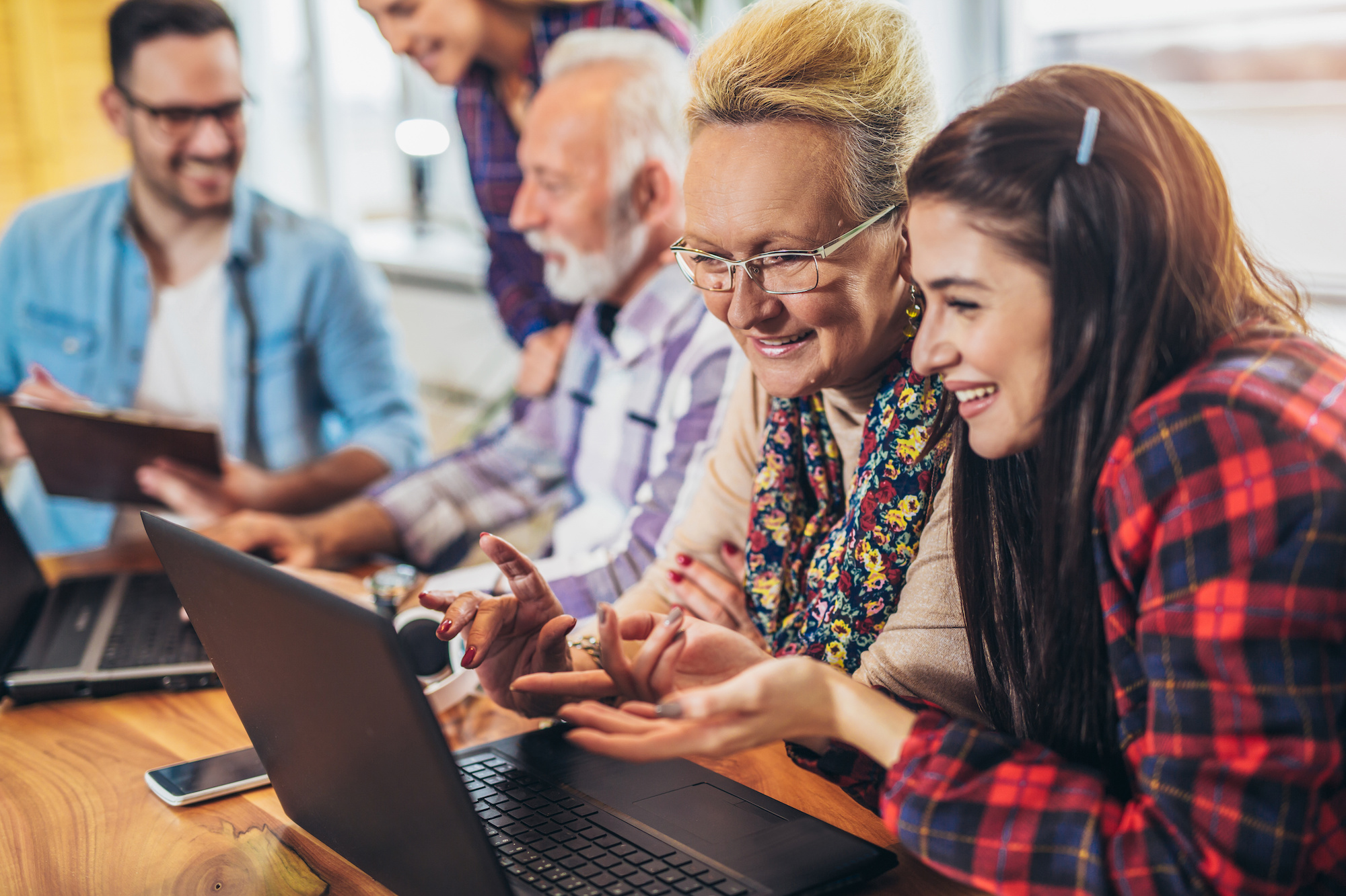 People of diverse ages working together around a computer