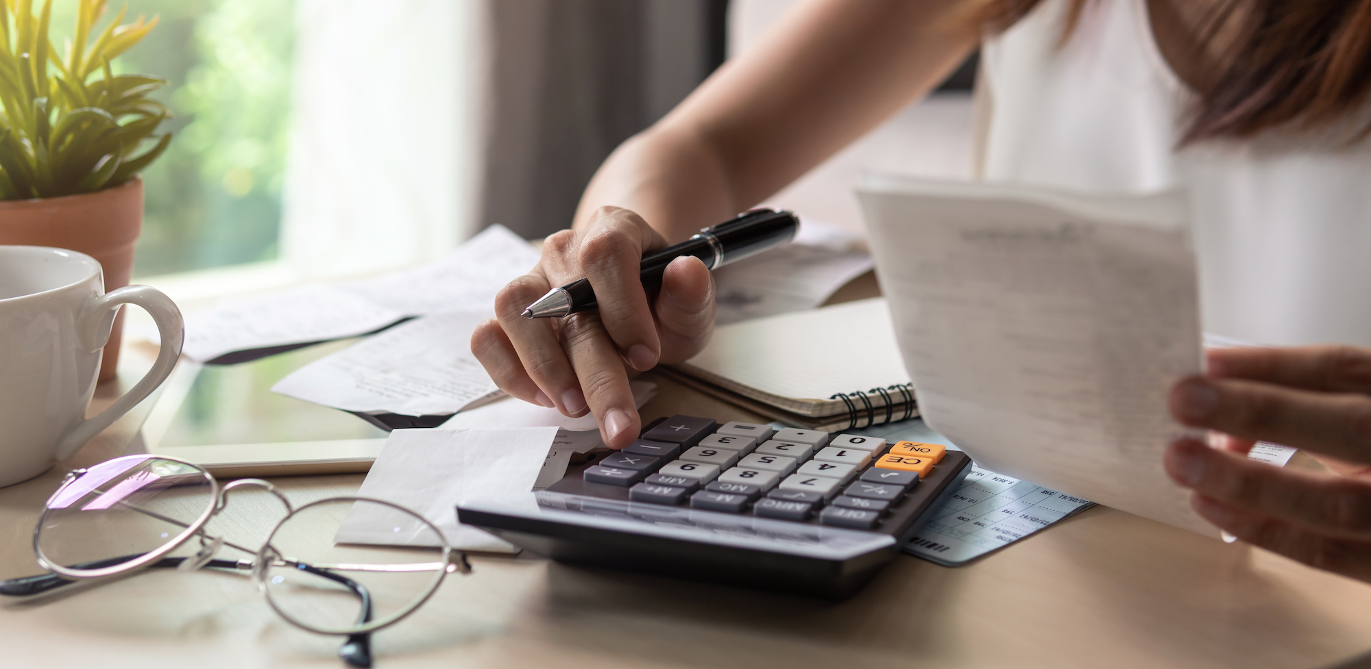 Image of woman using a calculator to check accounts