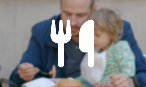 A blurred image of a man feeding a child