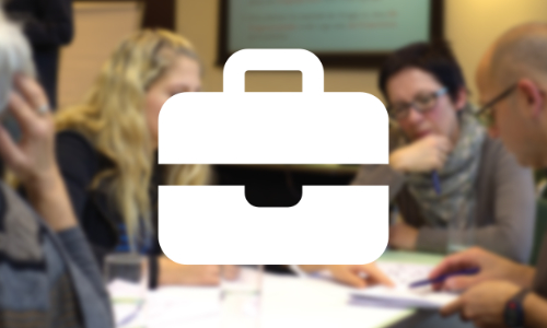 a blurred image of people looking at papers round a table with a briefcase icon overlayed