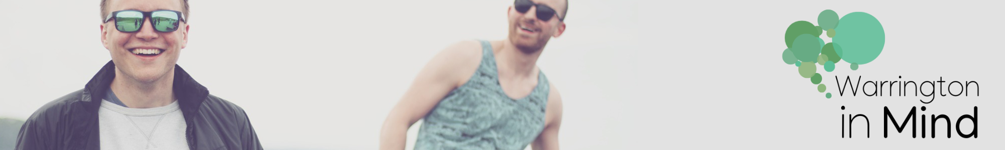 An image of two smiling men wearing sunglasses and the WiM logo